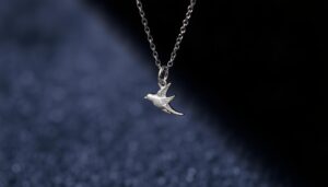 Srebrny naszyjnik z jaskółką symbol biżuteria na aksamitnym tle